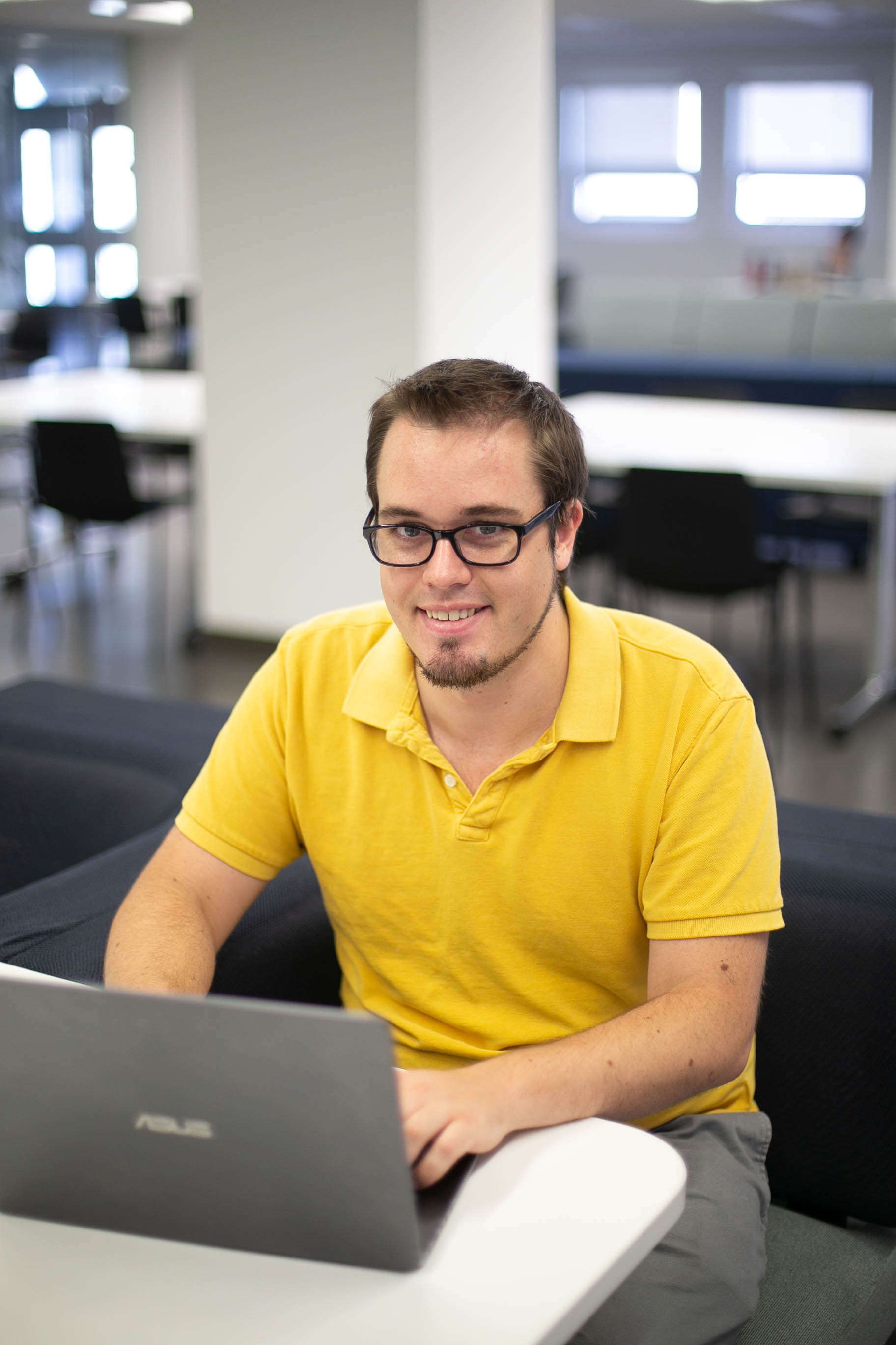 Joshua Mcconnell utilise son ordinateur portable en étant assis sur un canapé